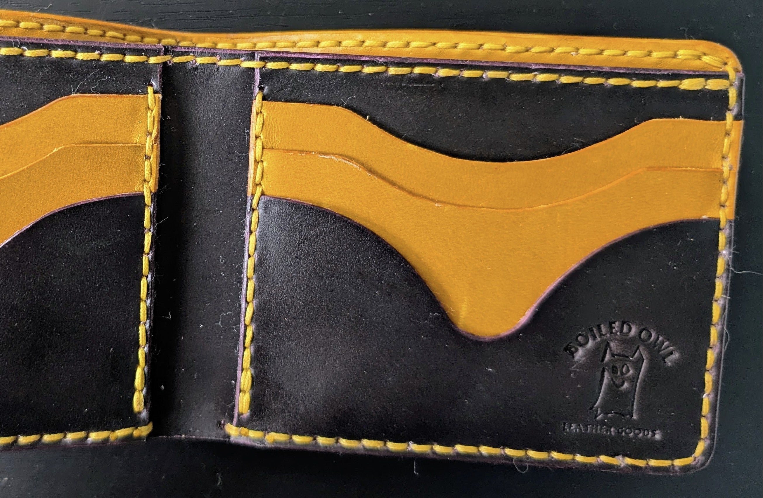 Black and orange leather wallet on a dark background